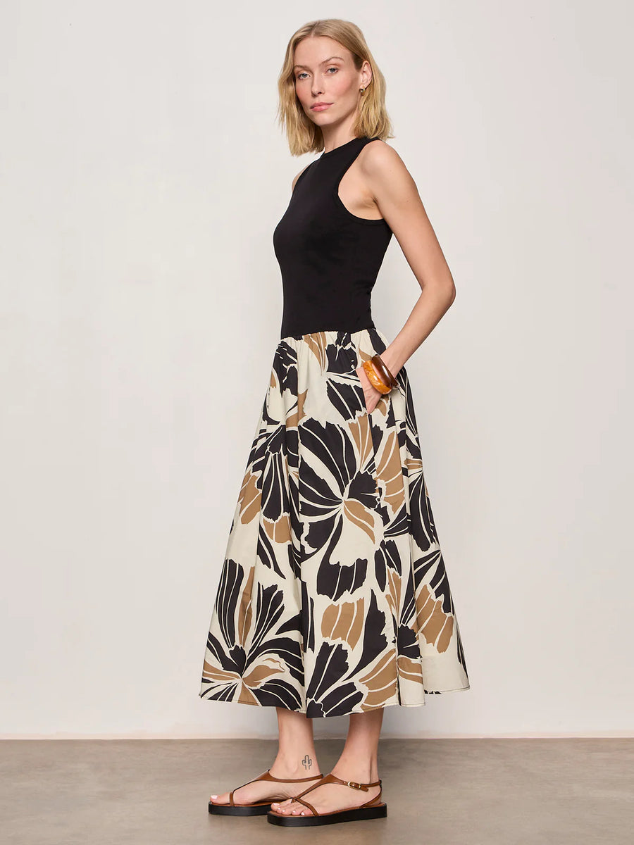 Woman wearing a black midi dress with lotus pattern detail 