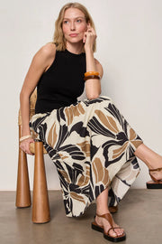 Woman wearing a black midi dress with lotus pattern detail 