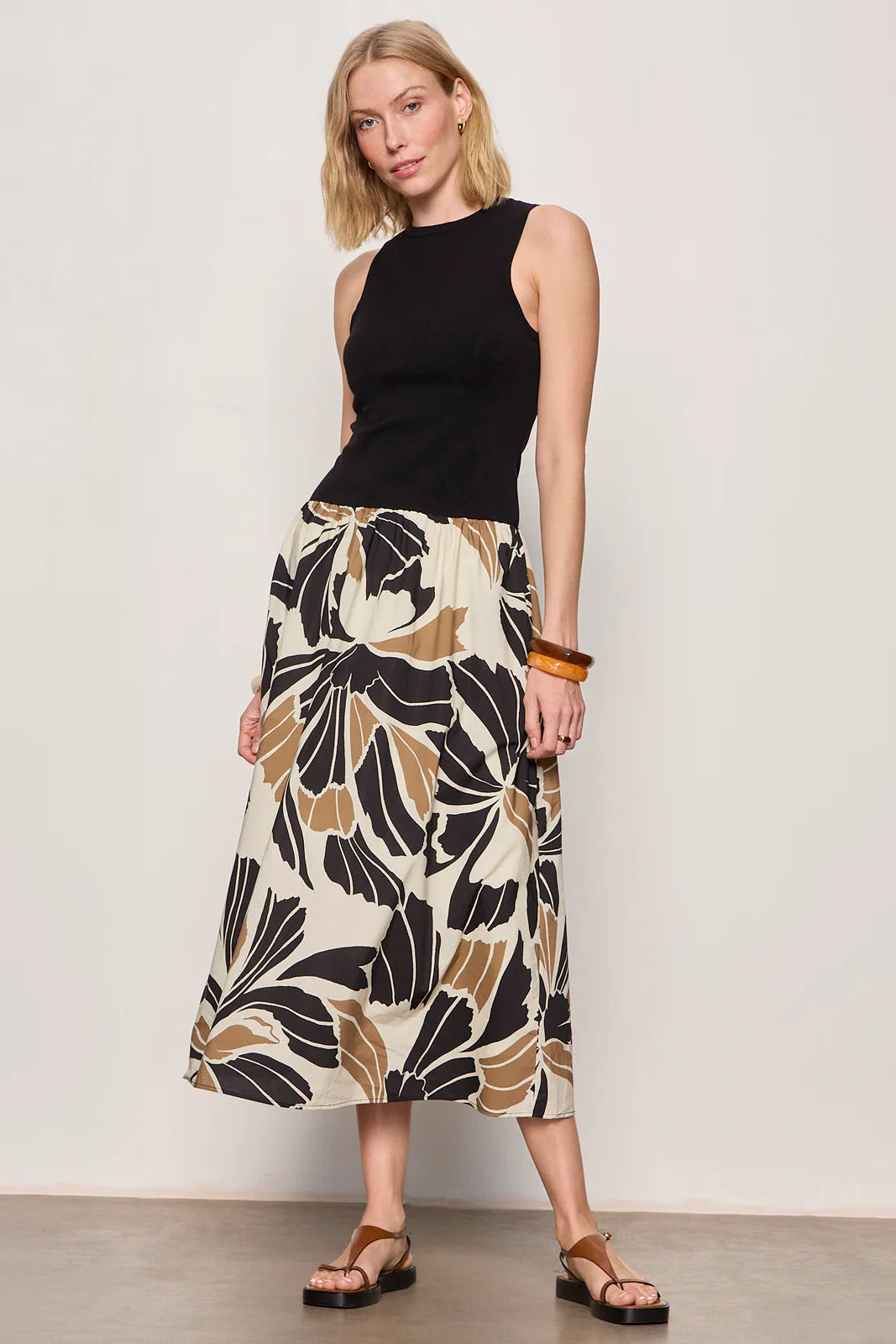 Woman wearing a black midi dress with lotus pattern detail 