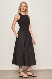 Woman wearing a black sleeveless knit midi dress with button up details