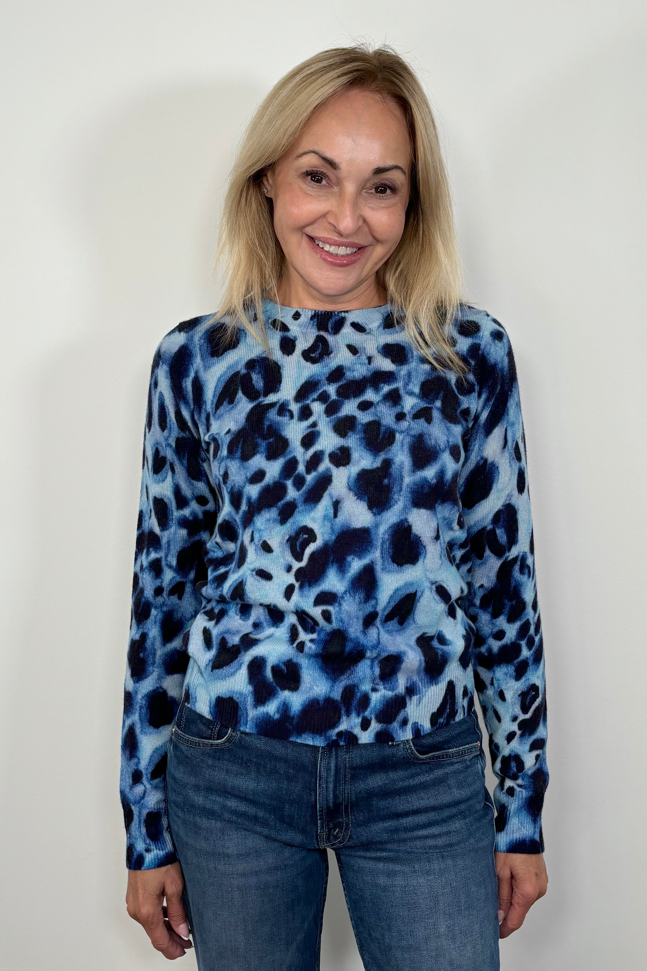 Woman wearing a blue watercolour animal print 100% cashmere long sleeve sweater
