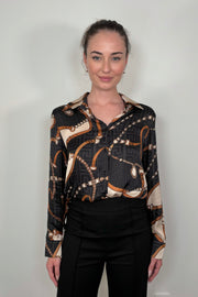 Front view of a woman wearing a printed button up shirt tucked in