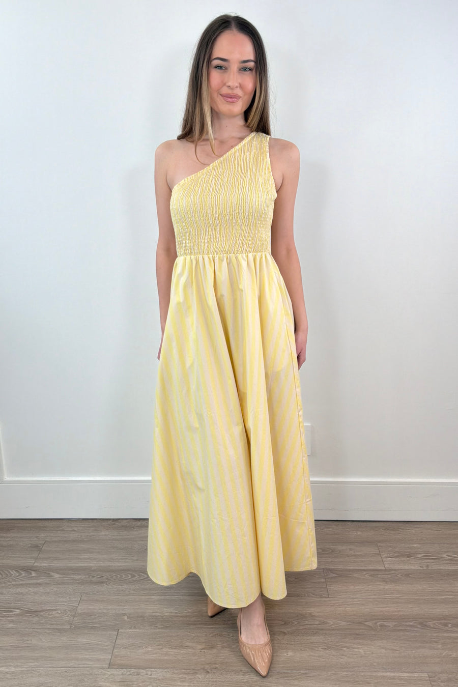 woman wearing a one-shoulder elastic torso yellow and white stripped dress