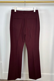 Burgundy pants hanging on a white hanger against a white background