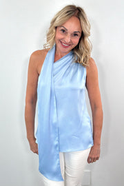 Woman wearing a light blue satin halter neck scarf blouse 