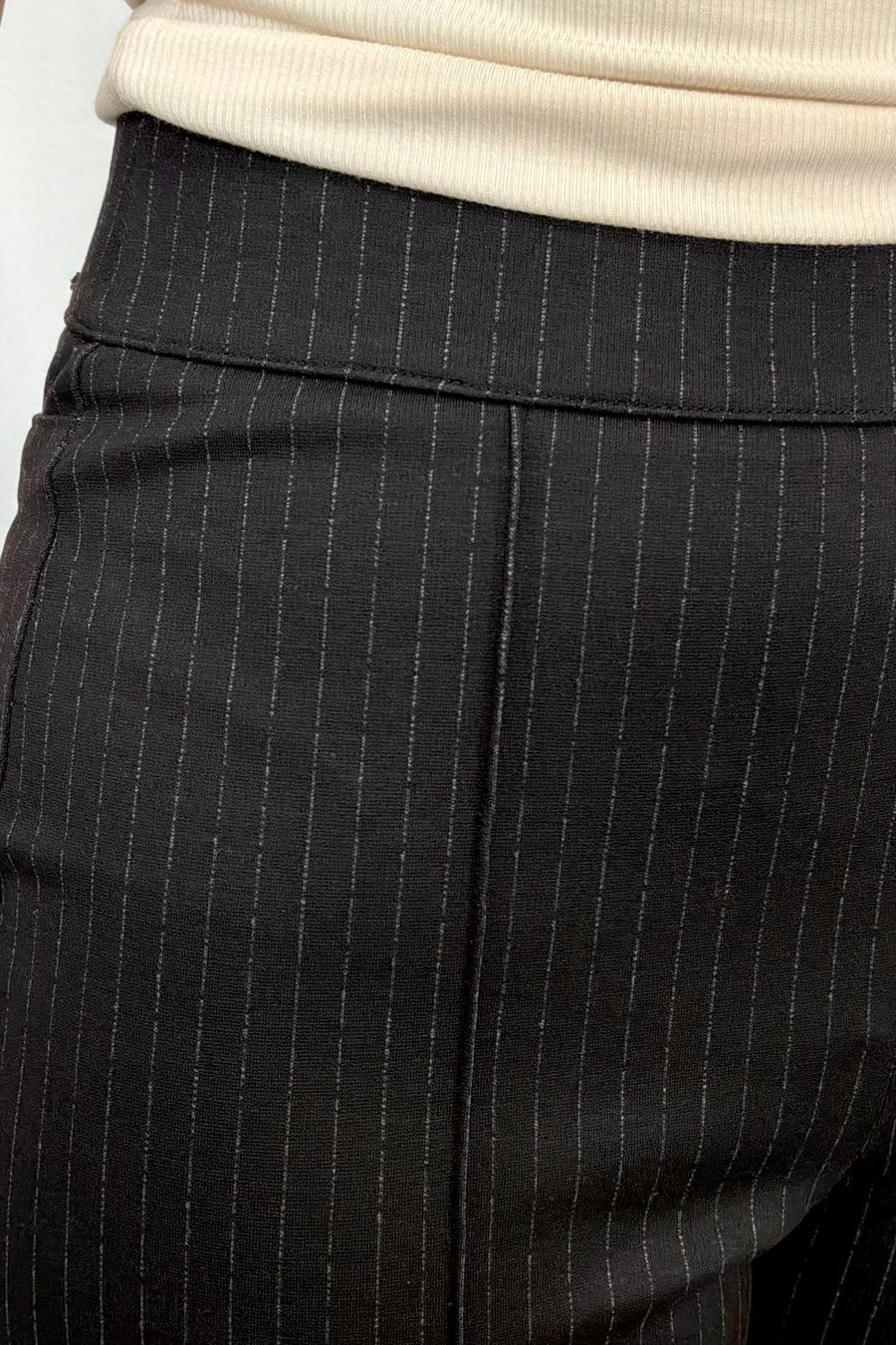 Person wearing black pinstripe pants