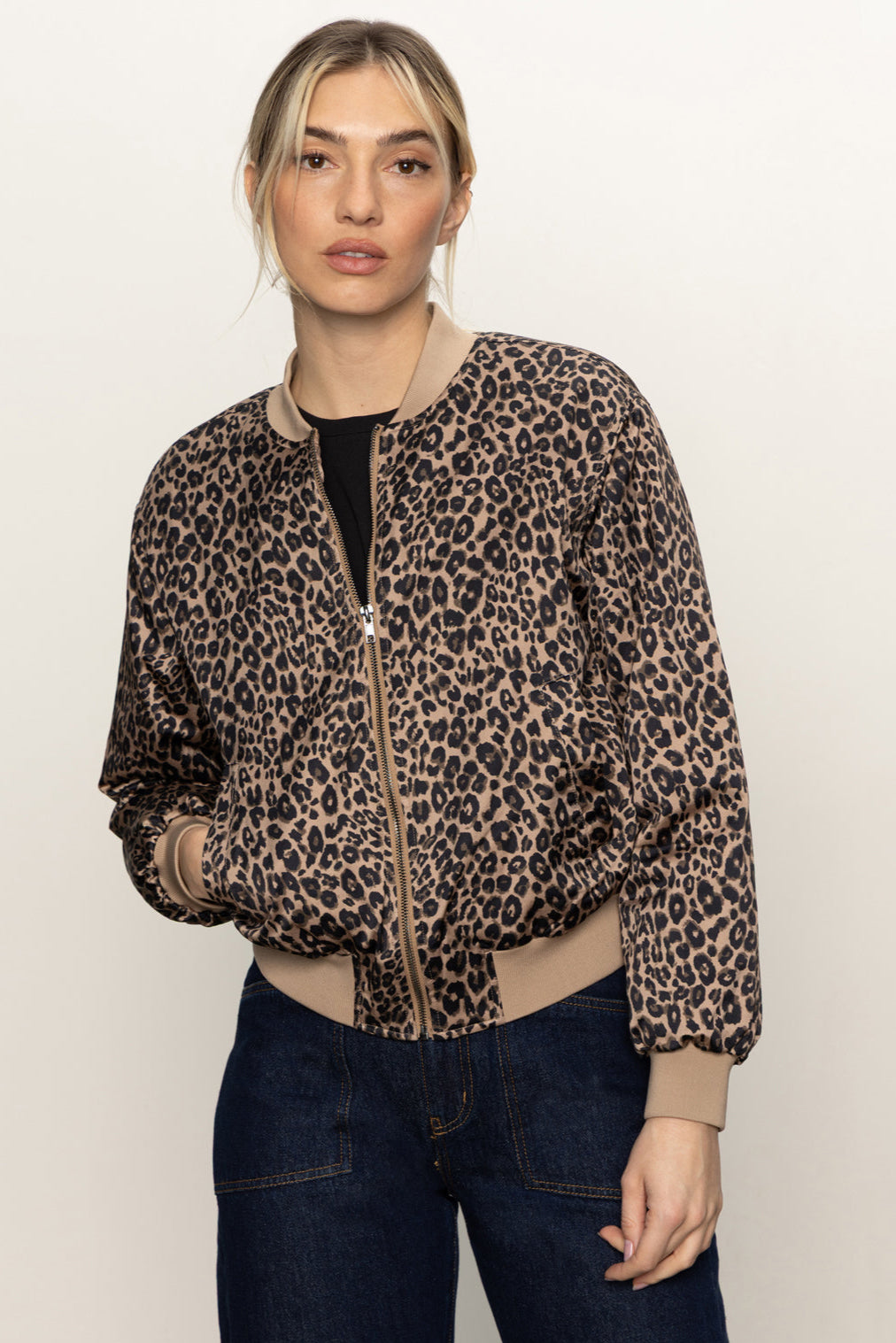 Front view of woman wearing a zipped up leopard print bomber jacket