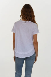 backview of woman wearing white v neck tee shirt with details on neckline