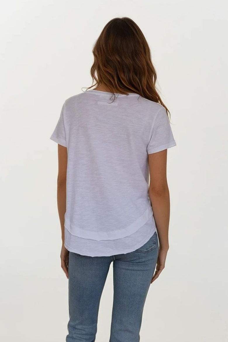 backview of woman wearing white v neck tee shirt with details on neckline