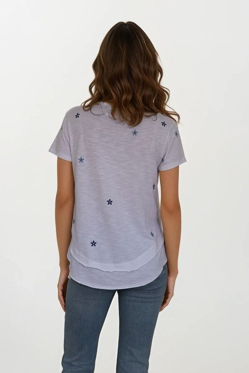 back view of woman wearing white mock layer t shirt with start details 
