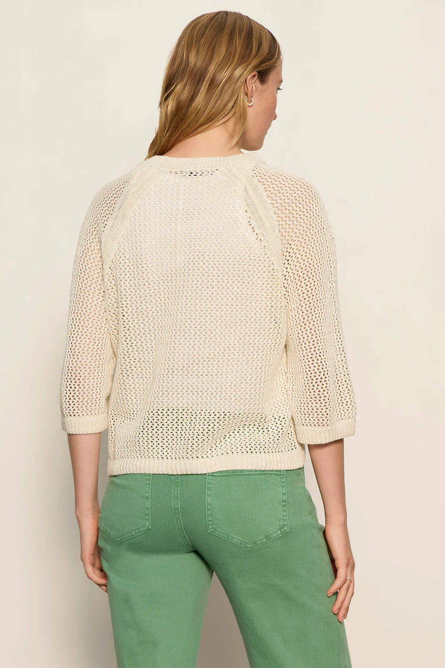 woman wearing a cream open-knit sweater with a relaxed fit and three-quarter sleeves, back