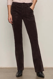 Person wearing brown corduroy pants against a plain background