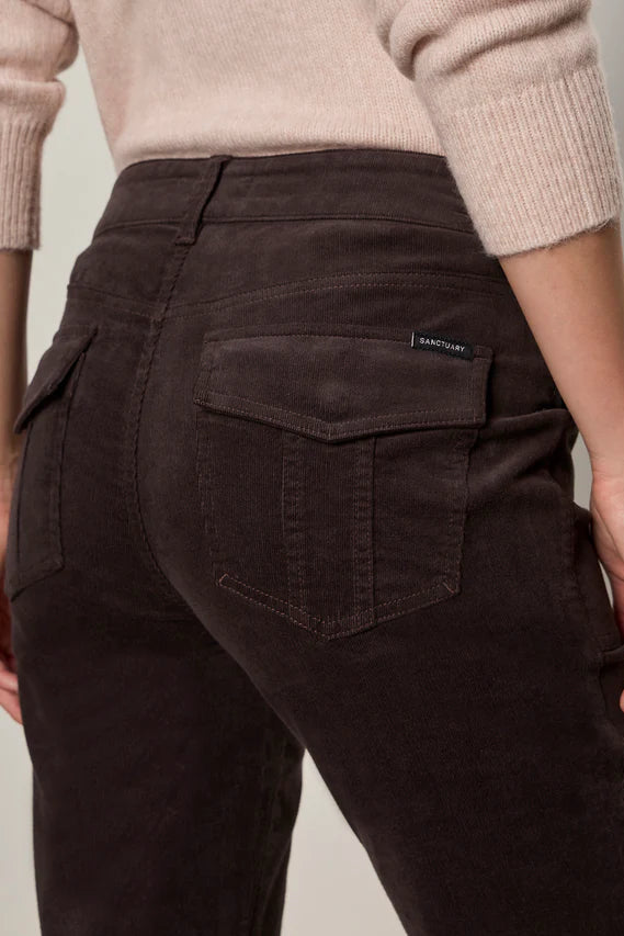 Person wearing corduroy brown pants on a neutral background