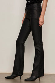 Side view of a person wearing black sculpted denim pants against a plain background