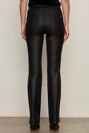 Back view of a person wearing black sculpted denim pants against a plain background