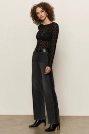 woman wearing washed black relaxed straight jean with lines on the sides and black textured tee