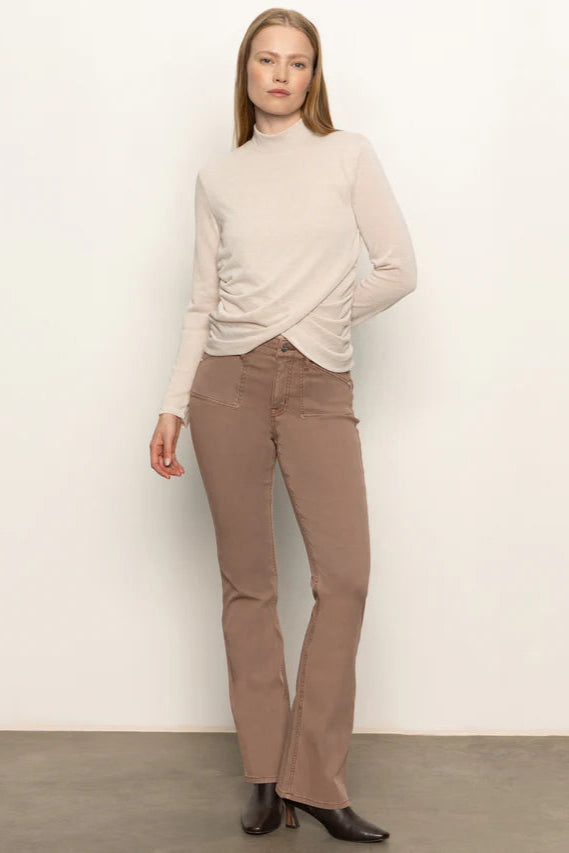Full body shot  of woman wearing a beige long-sleeve top with rouching in both sides