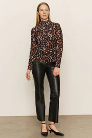 Woman wearing a mesh leopard print top and black pants