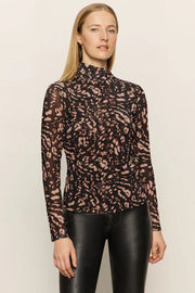 Woman wearing a mesh leopard print top and black pants