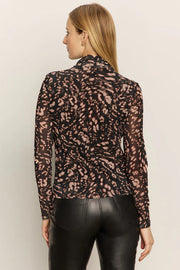 Woman wearing a mesh leopard print top and black pants
