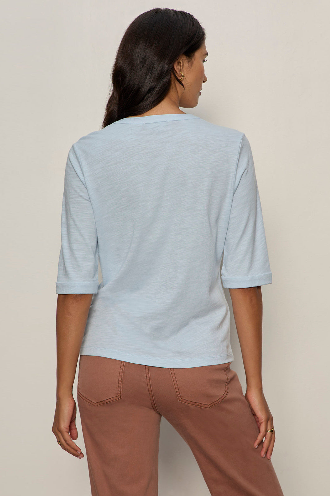 back vie of baby blue 3 button vneck with rolled sleeves