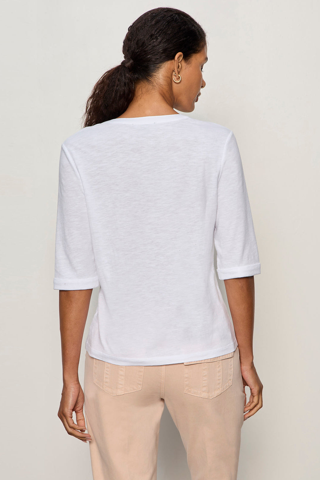 back view of white 3 button v neck top with rolled sleeves