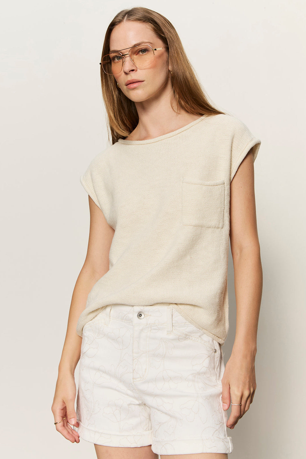 a woman wearing a cap sleeve tee shirt with a front pocket