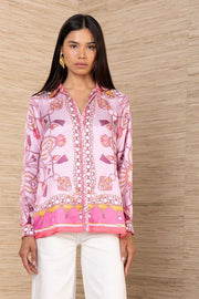 woman wearing a pink silk button down with rouching on the sleeves untucked