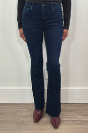 Person wearing frayed dark blue jeans 