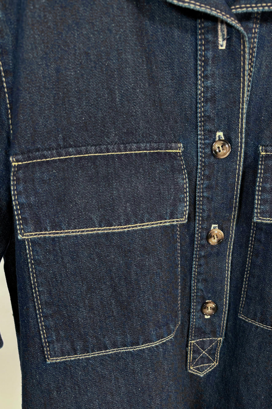 Close-up of the pocket of a dark blue denim dress 