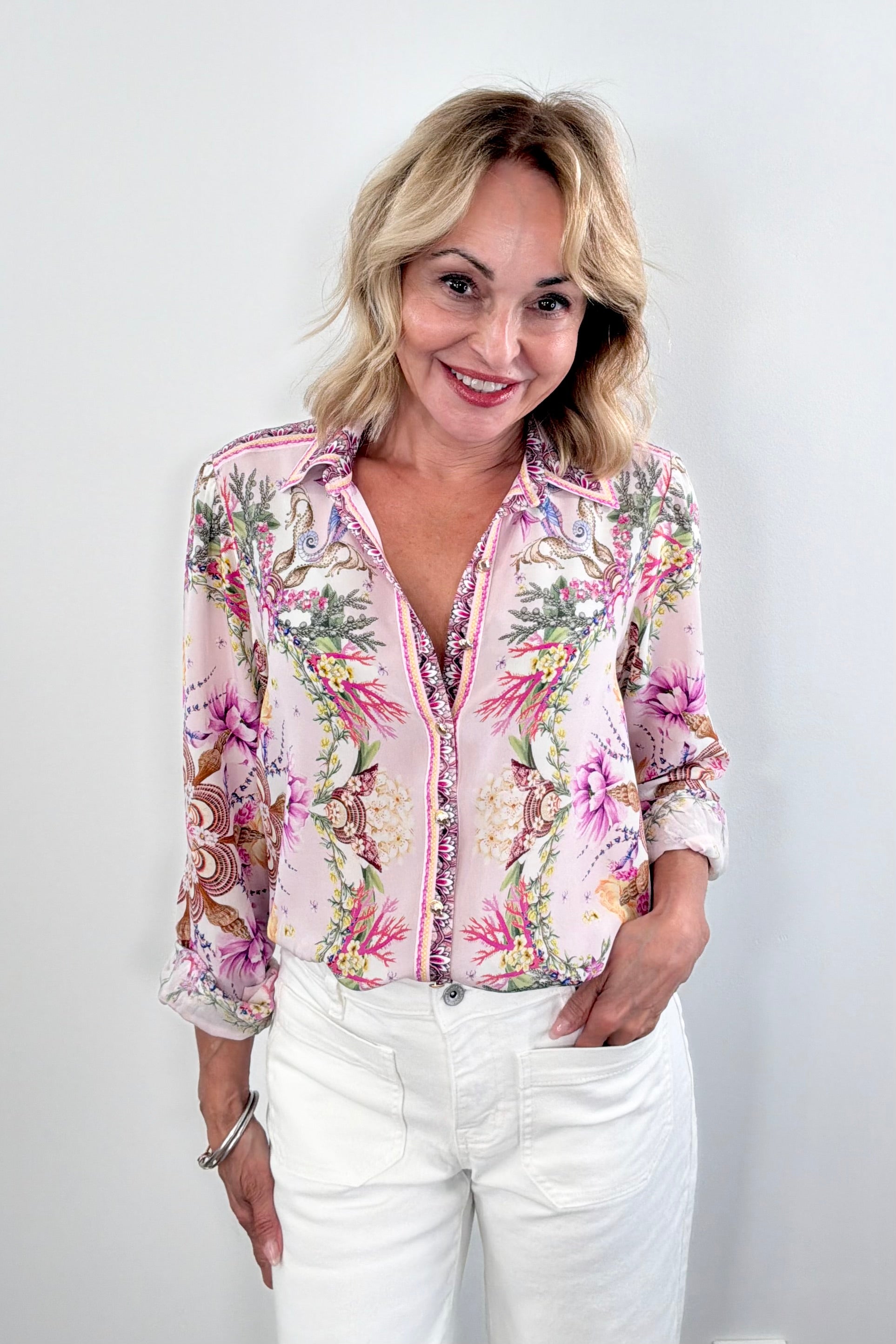 Woman wearing a floral blouse with a shell pattern 