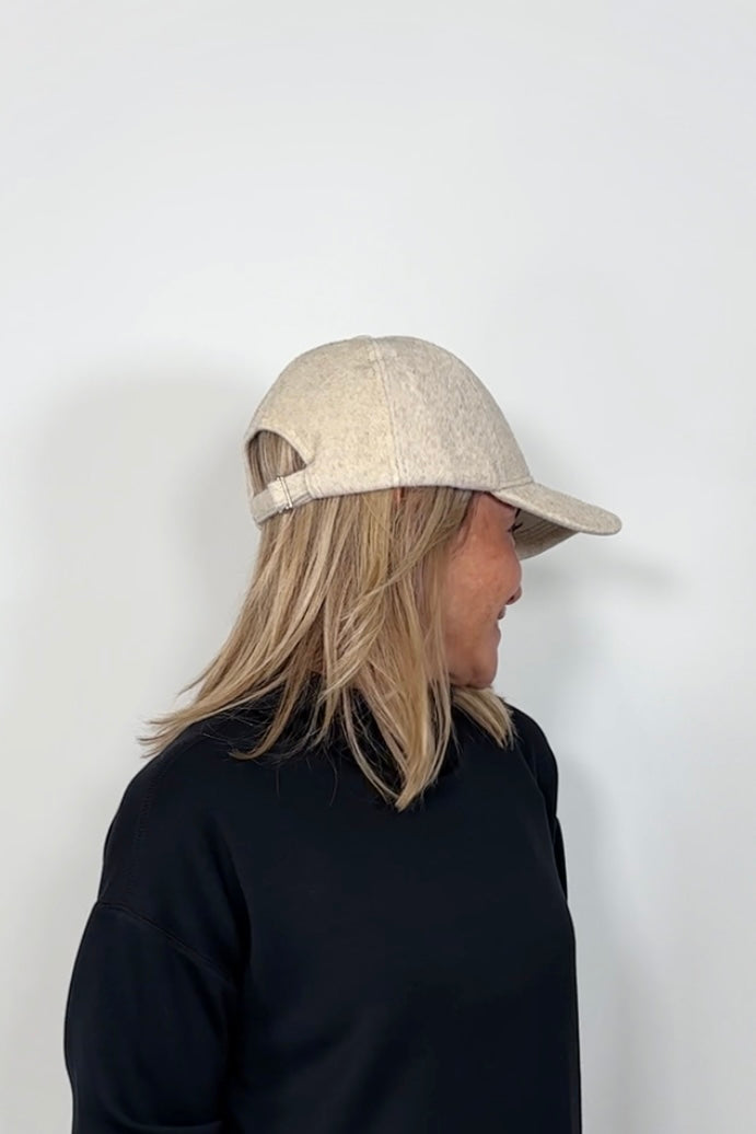 Side view of a woman wearing an oat coloured baseball felt hat
