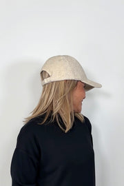 Side view of a woman wearing an oat coloured baseball felt hat