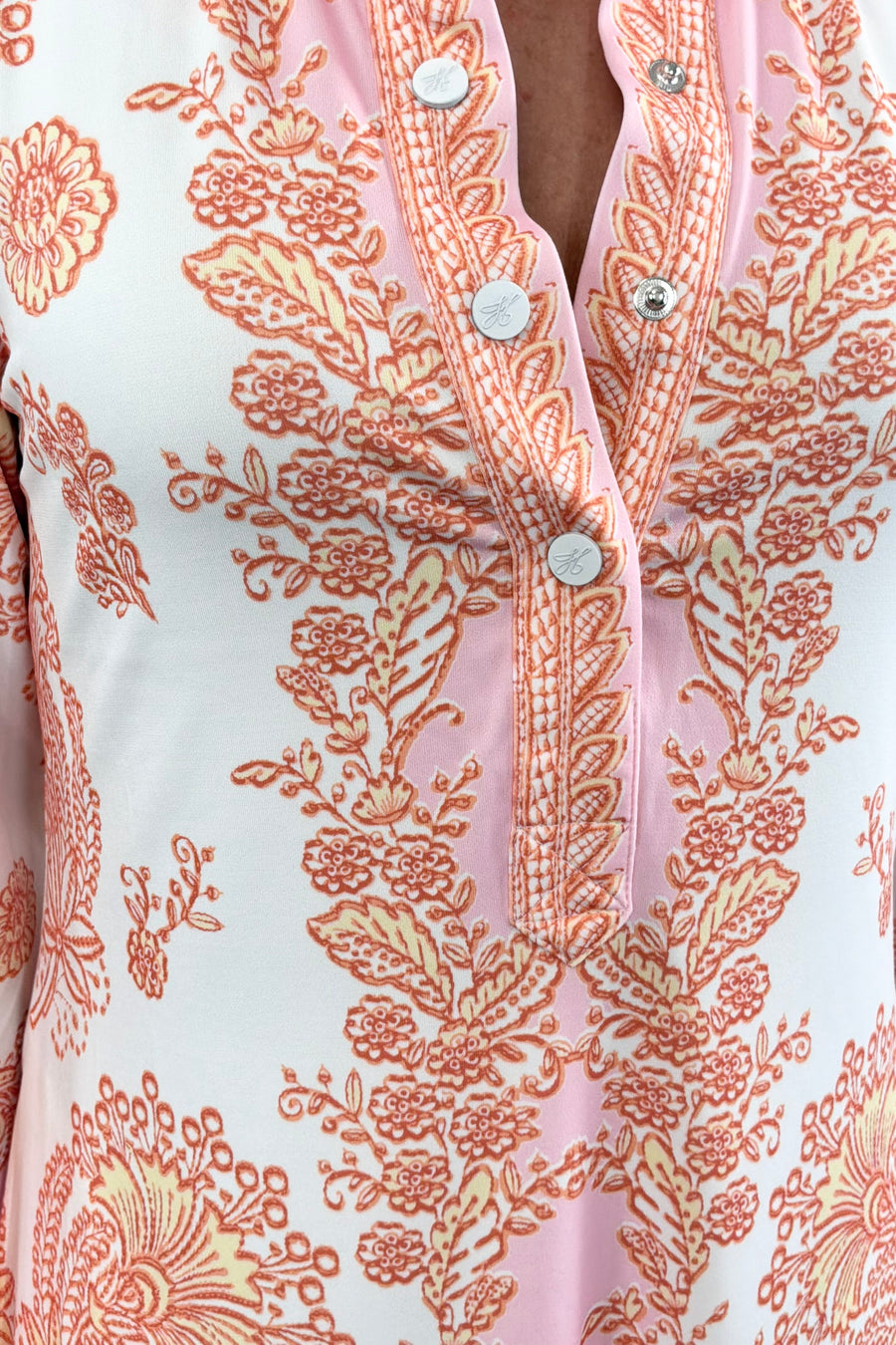 Women wearing v-neck dress with pink and orange patterns 