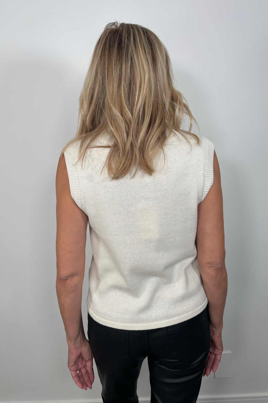 Back view of a woman wearing a sleeveless mix media tank top