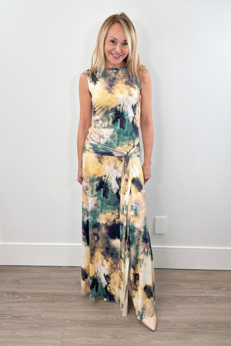 Woman wearing a colorful printed leg slit dress with a waist tie deail