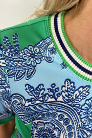 Close up of woman wearing a silk green and blue patterned tee