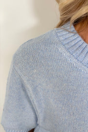 Close up view of woman wearing a light blue half sleeve sweater’s collar