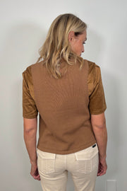 Back view of a woman wearing a suede leather and crochet top