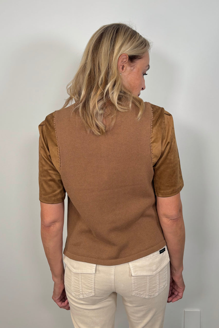 Back view of a woman wearing a suede leather and crochet top