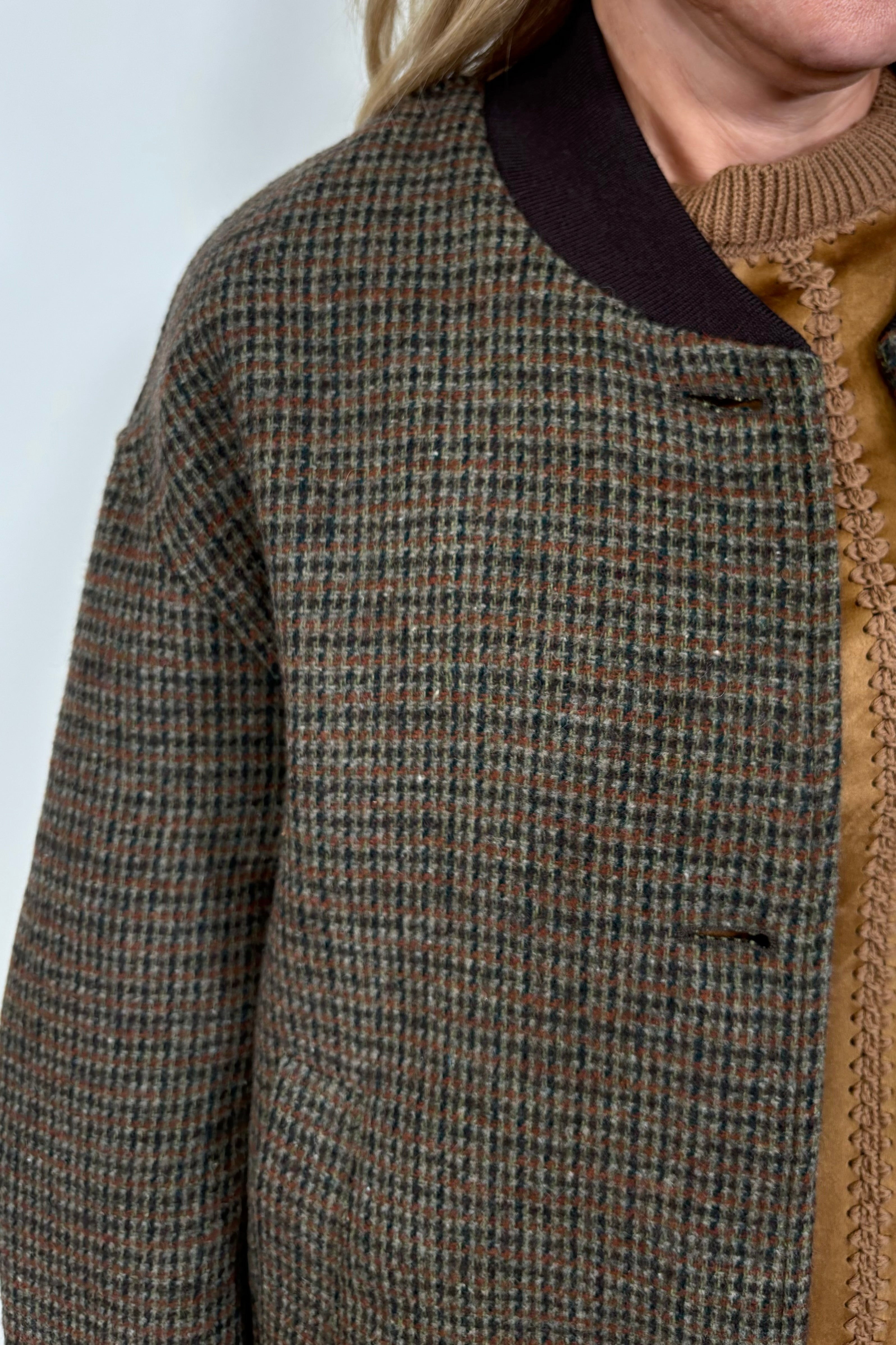 Close-up of a green and brown plaided bomber jacket