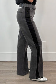 woman wearing washed black relaxed straight leg jeans with a black stripe on the sides