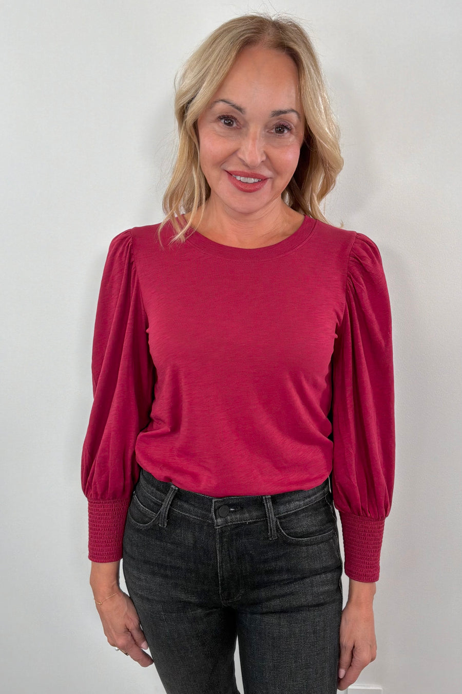 Woman wearing a red blouse with puffed sleeves 