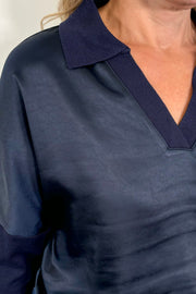 Close-up of the neck of a navy jersey and satin long sleeve collared too