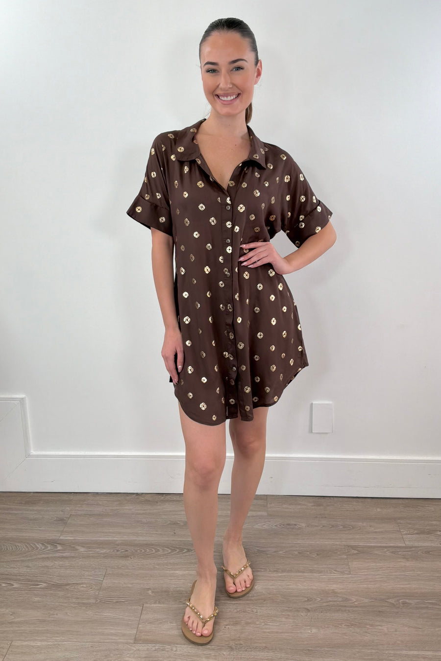 woman wearing a brown short shirt dress with gold detailing