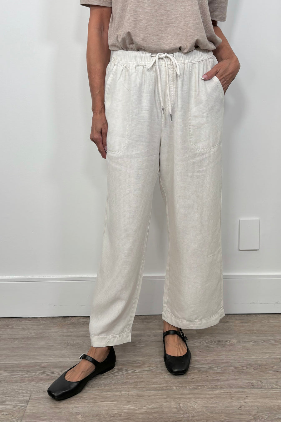 Front facing woman wearing cropped light weight  white pants