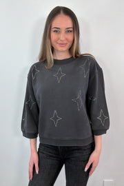 woman wearing gray sweatshirt with stud stars