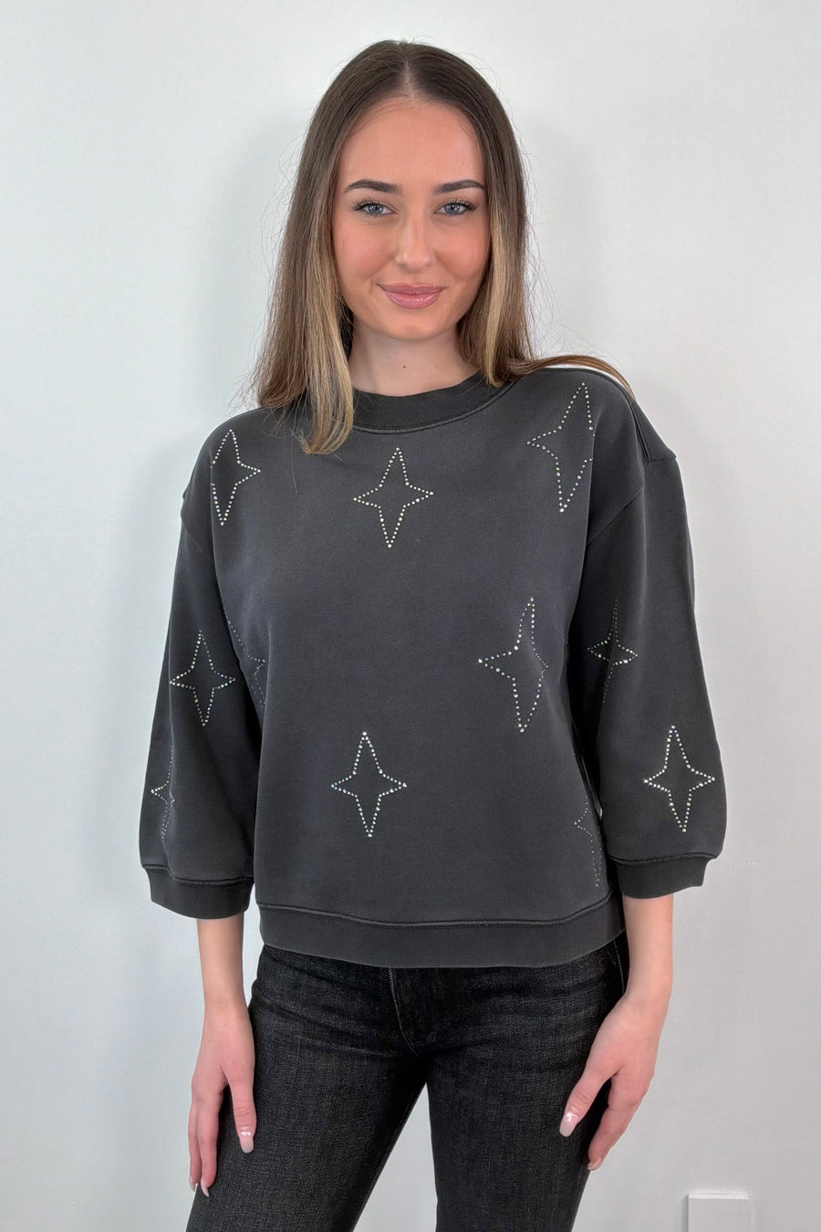 woman wearing gray sweatshirt with stud stars