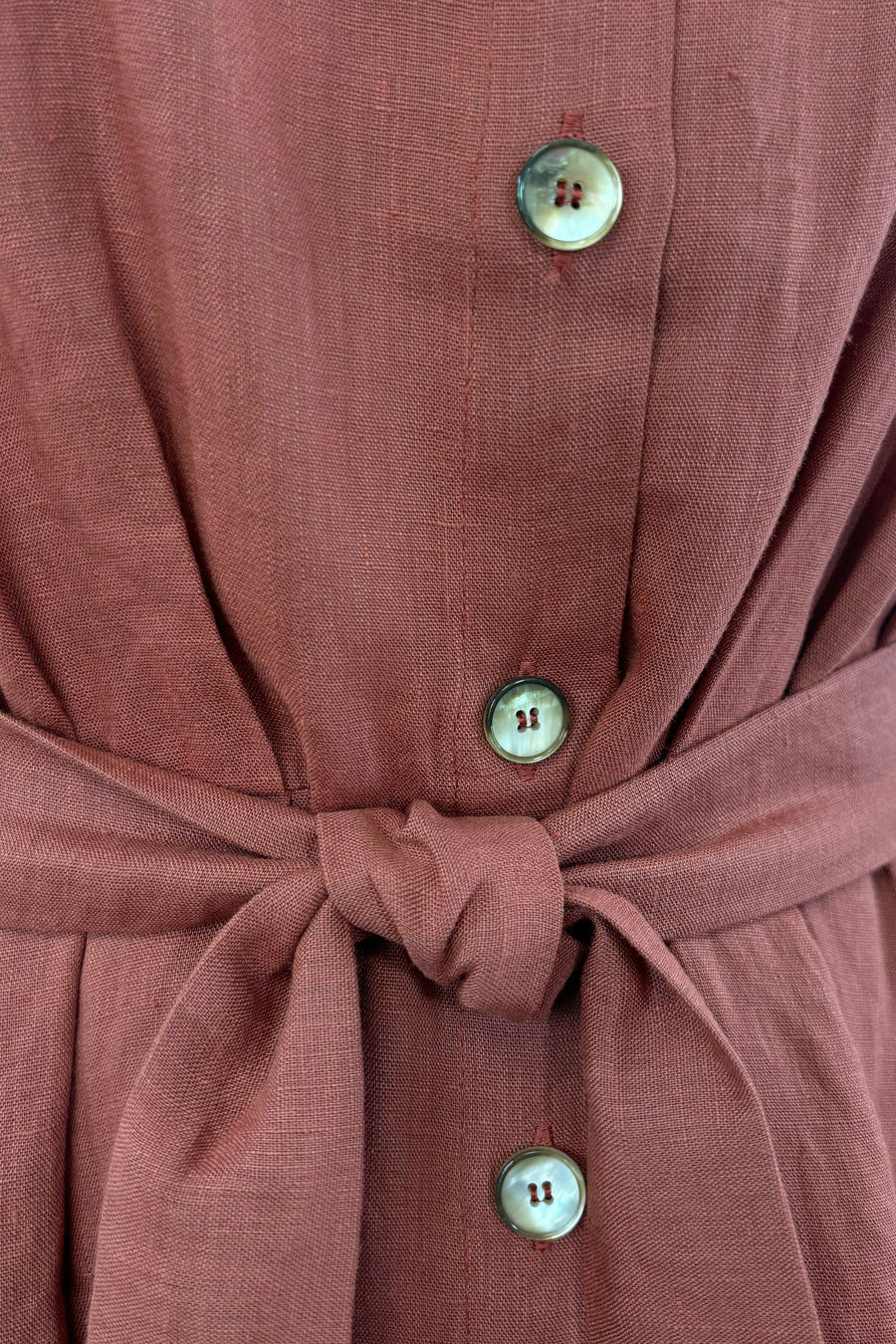 Close up of button up detail and belt finish