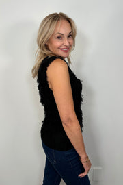 Side view a woman wearing a black tank top with fine gauge fringes 